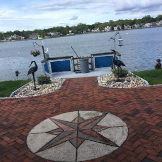 A serene lakeside view with a decorative pathway leading to the water.