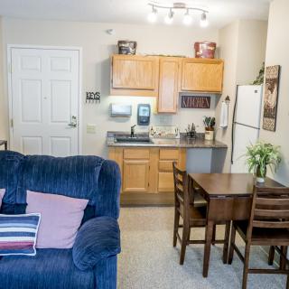 A cozy apartment with an open layout featuring a small kitchen and living area.