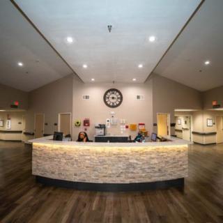 A spacious reception area with a curved desk and warm lighting.