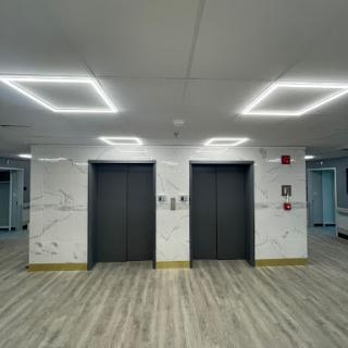 A modern elevator lobby featuring sleek designs and bright lighting.
