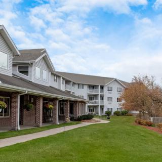 A view of a residential apartment complex with well-maintained lawns and landscaping.