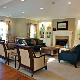 A spacious and elegantly decorated living room featuring a fireplace, comfortable seating, and tasteful decor.