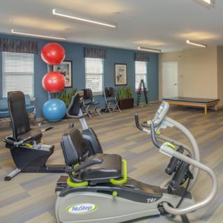 A modern gym with various exercise equipment including stationary bikes and exercise balls.