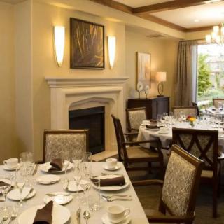 An elegant dining room with a formal table setting and a cozy fireplace.