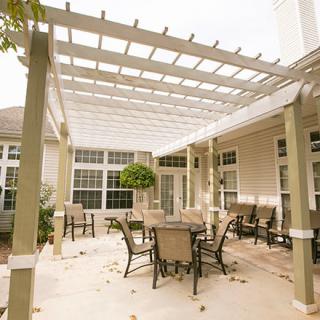A cozy outdoor patio area with a pergola and seating arrangement.