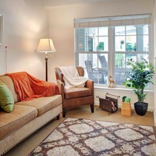 A cozy living room with a sofa, armchair, and a large window.