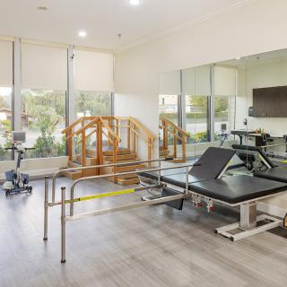 A well-equipped physical therapy room featuring various exercise and rehabilitation equipment.