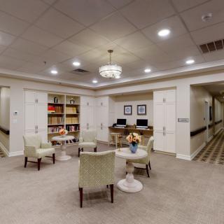 A cozy seating area with bookshelves and computers in a well-lit room.