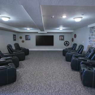 A spacious home theater with multiple recliners and a large screen.