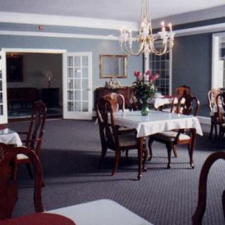 A sophisticated dining room with elegant furnishings and a chandelier.