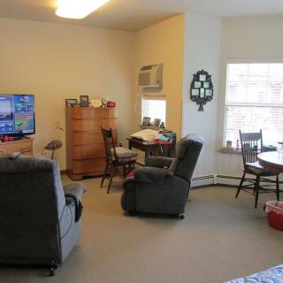 A cozy living room with comfortable seating, a TV, and natural light from a window.