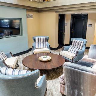 A cozy seating area featuring several striped armchairs arranged around a wooden coffee table.