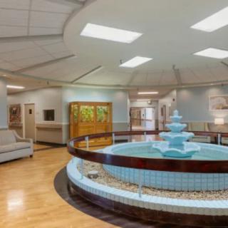 An elegant lobby interior featuring a central fountain and seating area.