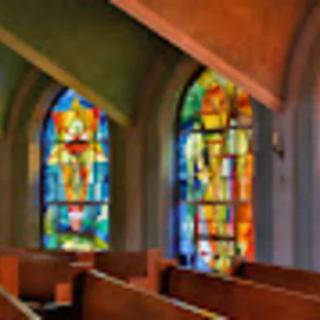 Interior view of a church with colorful stained glass windows.