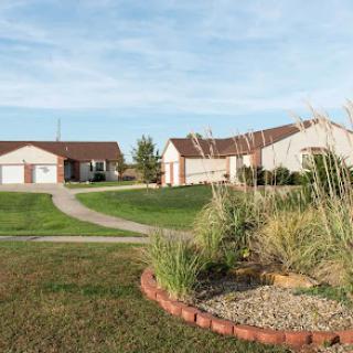 A serene suburban landscape featuring well-maintained houses and lush greenery.