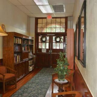 A cozy hallway with a bookshelf and seating area, adorned with decorative elements.