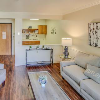 A cozy living room with modern furniture and an adjacent kitchen area.