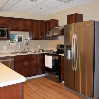 A modern kitchen featuring wooden cabinets, stainless steel appliances, and a sleek design.