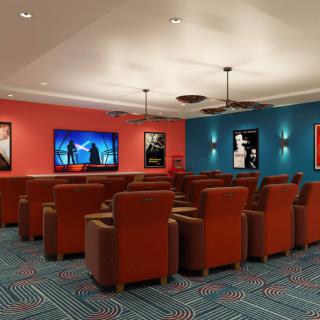 A cozy home theater room with recliner seating and colorful walls adorned with movie posters.