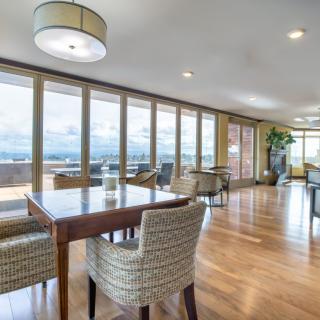 A spacious dining area with modern furniture and large windows providing ample natural light.