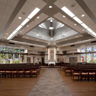 Interior view of a modern church featuring stained glass windows and an altar.