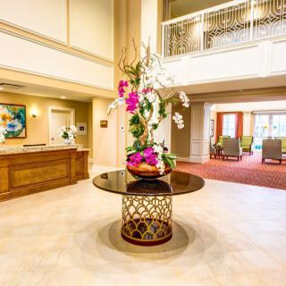 A beautifully decorated lobby with a flower arrangement on a central table.