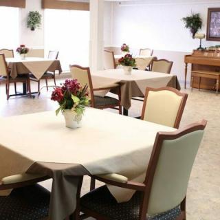 A neatly arranged dining area with tables, chairs, and floral decorations.