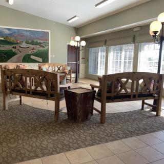 A cozy lobby area with wooden benches and soft lighting.
