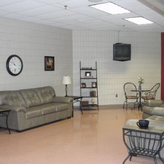 A simple and modern living room setup featuring a comfortable sofa, decorative shelf, and a television.