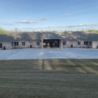 A large house with a spacious driveway under a clear sky.