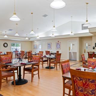 A spacious and well-lit dining area with neatly arranged tables and chairs.