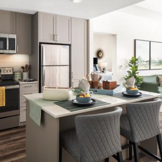 A modern kitchen with an island seating area, featuring sleek appliances and elegant decor.