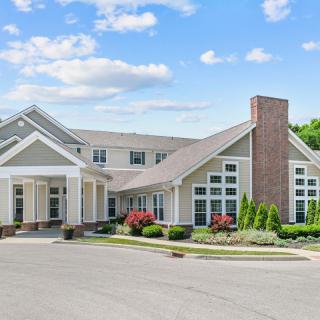 A suburban residential building under a partly cloudy sky.