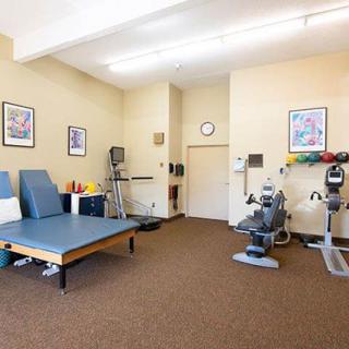 A well-equipped physical therapy room with exercise machines and rehabilitation equipment.