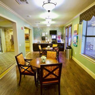 A cozy dining area with a polished wooden floor and elegant lighting.