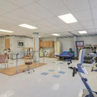 A spacious rehabilitation center equipped with exercise machines and therapy areas.