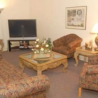 A cozy living room with patterned furniture and a large television.