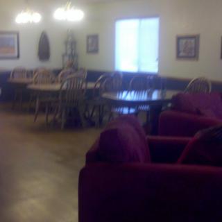 A cozy dining area with wooden tables, chairs, and plush sofas.