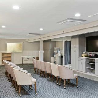 A modern conference room with rows of chairs facing a large television screen.