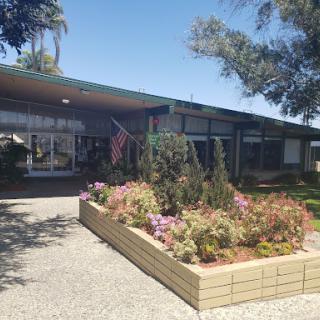 A well-maintained building surrounded by vibrant flowers and greenery.