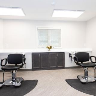 A modern and minimalist salon interior featuring two styling chairs.