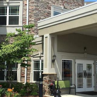 Front entrance of a modern residential building with a landscaped exterior.