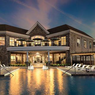 A luxurious home with a beautiful swimming pool illuminated in the evening.
