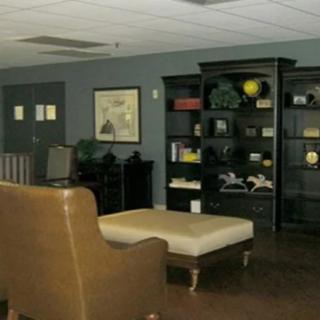 A cozy office lounge area with a seating arrangement and bookshelves.