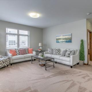 A modern living room with two sofas, a glass coffee table, and decorative elements.