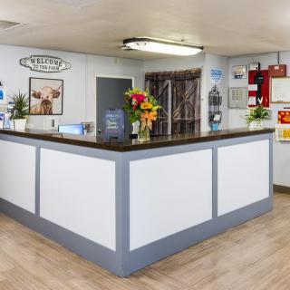 A well-organized reception desk area with floral decorations and informational displays.
