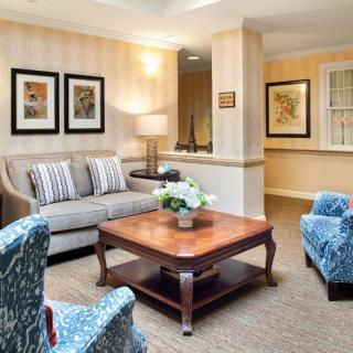 A cozy living room with a sofa, coffee table, and framed artwork on the walls.
