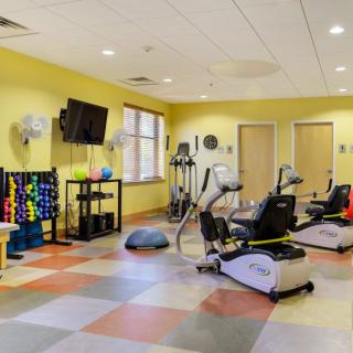 A well-equipped fitness center with various exercise machines and weights.