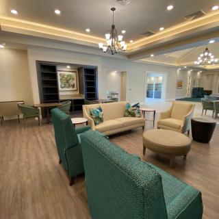 A modern lounge area featuring comfortable seating and elegant chandeliers.