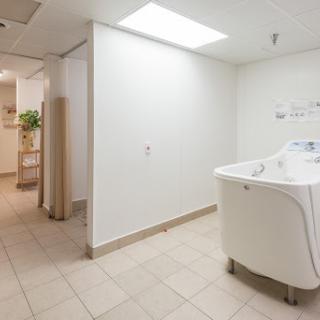 A bright and clean laundry room featuring a washing machine and tiled flooring.